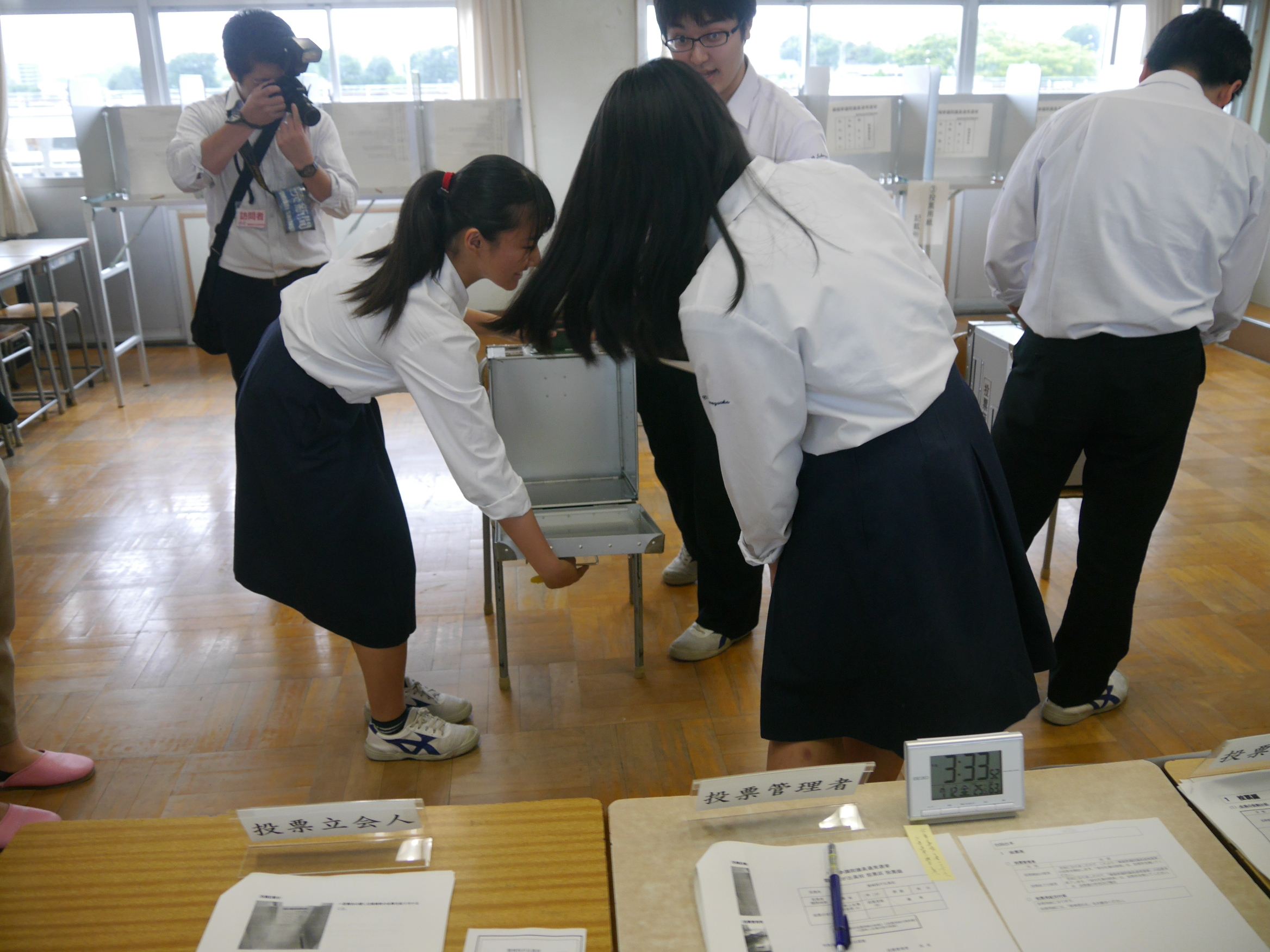 一番最初に受付した選挙人が投票箱が空かどうかをチェックしている様子